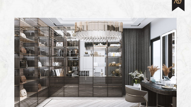 A modern interior with a lounge area featuring two white sofas and a white armchair, with a centre table. The walls and floors are covered in light beige marble and accented with white and gold inlay.