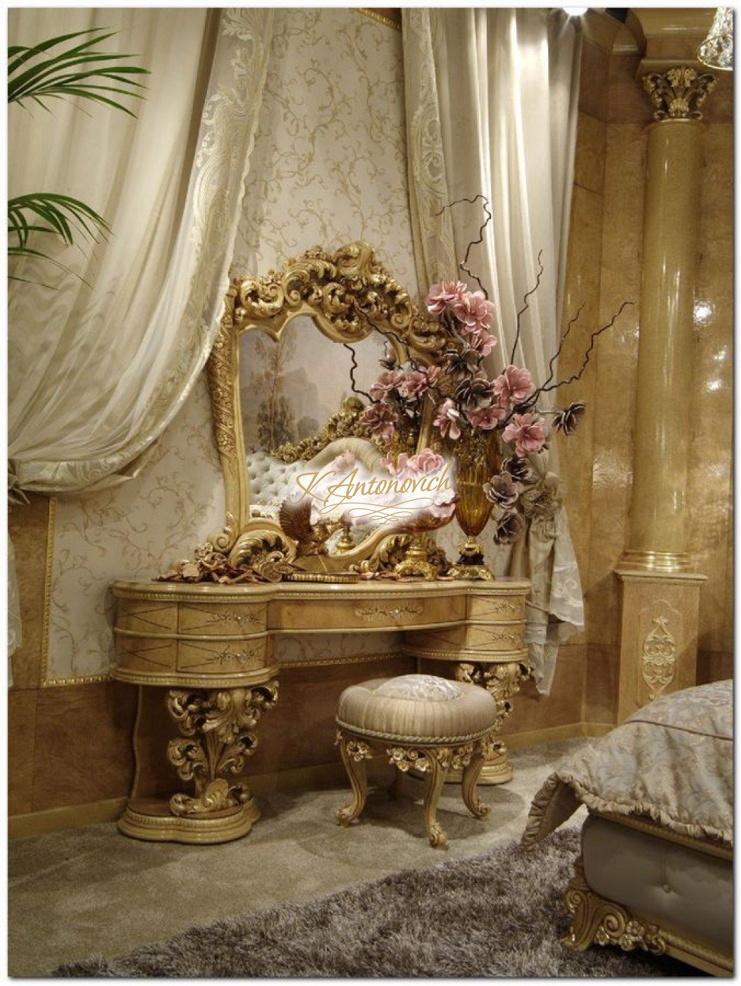 This picture shows a luxurious bathroom with a freestanding bathtub. The tub is white and has gold detailing around the top and bottom edges. The walls are a light grey and are decorated with elegant gold tiles. The floor is also a light grey with black accent tiles near the center. There is a large window in the background looking out onto a cityscape. The room also contains two vanities with stone sinks, one on either side of the tub, and two separate shower stalls with glass panels.