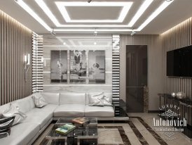 This is a picture of a modern living room in a luxury apartment which features contemporary decor. The space has an overall bright, white color scheme with a wallpapered accent wall and modern furniture pieces in classic silhouettes. A large black and white abstract painting hangs on the left wall, while a sleek lounge chair with a geometric patterned rug and unique lighting fixtures are placed to the right. The room also includes a floor-to-ceiling window with views of the city skyline.