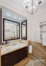 Modern classic style luxury bathroom with a golden washbasin and white marble walls with decorative details.