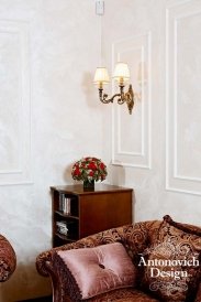 Modern and luxurious interior design with gold-accented furniture pieces, velvet curtains, classy artwork, and classic chandelier.