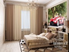 This picture shows a luxurious modern living room with a beige sectional sofa and armchairs, accented by a round glass coffee table. Along the walls, there are wooden cabinets and shelves for displaying artifacts and curios, and light brown curtains with a white valance frame the windows. The hardwood floor is covered with a white and gray patterned rug, and the walls are painted white. An elegant chandelier hangs from the ceiling, adding a touch of glamour to the room.