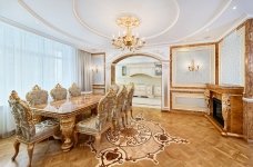 Modern luxury living room design with two armchairs and a sofa set in white and gold colour scheme.