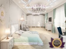 Interior of a luxuriously designed bedroom with a large chandelier, grey and white patterned walls, and a terrace view.