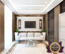 This picture shows an intricately designed marble countertop with a mosaic patterned backsplash. The countertop is curved with a polished finish and is supported by an ornate column featuring gold detailing. The backsplash is made up of several interlocking pieces of marble in various shades of white, cream, and grey.