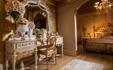 Luxury interior of a palace includes a classic chandelier, ornate gold furniture and gilded walls - ideal for a royal home.