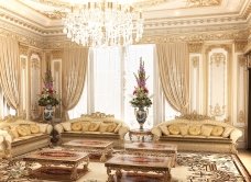 This picture shows a luxurious living room with furniture upholstered in gold and cream fabrics. The walls are covered in a light cream color and decorated with beige and gold wallpaper. There is a large area rug covering the floor and a long, comfortable sofa dominating the center of the room with several armchairs arranged around it. On the walls, there are two large paintings, a sculptural lamp, and some decorative items.