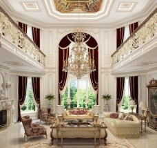 This picture shows a modern, luxury bathroom. The room is decorated with white marble tiles on the walls and floors and has golden fixtures, including a sink, toilet, shower, and heated towel rack. There is a large window that overlooks a scenic mountain range, allowing natural light to flood the space. A luxurious crystal chandelier hangs from the ceiling, adding a touch of glamour.