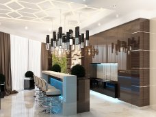 The picture shows an elegant, modern bathroom in a luxurious residence. The space features marble flooring that leads to white walls, as well as a large, glass wall shower enclosure and luxurious gold fixtures that adorn the walls, including several framed mirrors. An ornate marble countertop holds two vessel sinks and a large, freestanding soaking tub is positioned in the middle of the room, with a window above it.