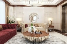 This picture shows a luxurious bathroom suite, decorated in marble and gold accents. The space includes two golden sinks, a large shower area with a gold and marble shower enclosure, a luxurious bathtub with a decorative marble surround, and a freestanding gold and marble double vanity cabinet. The walls and floor are finished in white marble, while the vanity and shower are clad in gold-colored metal and marble panels.