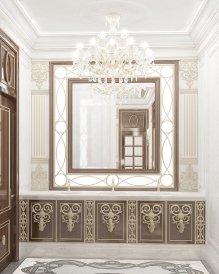 This picture is of a grand ornate staircase with a curved banister and intricate ceiling details. The staircase is located in a large entryway adorned with gold fixtures, and white marble columns. The entryway is brightly lit, and the walls and floor are decorated with intricate patterns and designs.