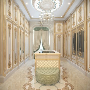 This picture shows an ornate and luxurious bedroom interior design. The bedroom is decorated with a large chandelier and numerous gold accents throughout the room. There is a large bed with a tufted headboard, draped with a gold and white duvet, flanked by two nightstands with gold lamps. The walls are painted in a pale pink color and have a pattern of gold and white circles along one wall. There is a window to the right of the bed, with cream curtains and sheer drapes. Lastly, the furniture pieces are upholstered in a soft blue