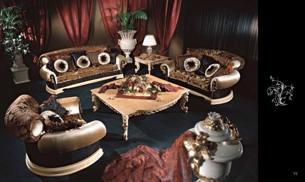 This picture shows a beautiful, elegant interior design of a luxurious living room. It features a white leather couch and armchair with a white ottoman in the center of the room. The walls are painted a pale blue color, while the ceiling is decorated with gold accents. A marble coffee table sits in front of the couch, and an ornate gold lamp stands at one side of the room. The room is further enhanced by a large gold-framed painting on the wall.