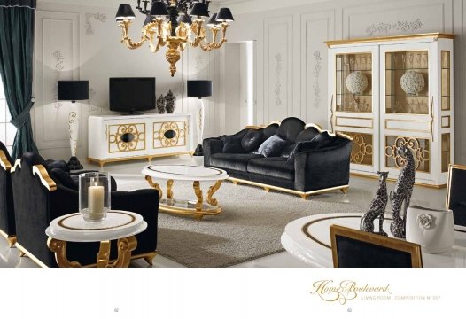 The picture shows a modern and sophisticated living room design. It features elegant wood floors, a luxurious white leather couch, two large velvet armchairs, a glass coffee table, and a small round side table. The walls are painted a light gray-blue color and adorned with art pieces and framed mirrors. The décor is further accentuated by a grand crystal chandelier hanging above.