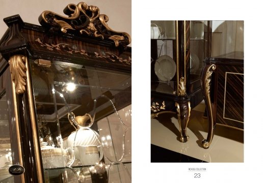 The picture shows an ornate, luxury white bathroom. It features a large sunken bathtub with gold fittings, a golden console with a marble top, and white tiled walls with a gold mosaic wall feature. There is a large sink with gold fixtures and countertops, and a floor-to-ceiling mirror framed in gold. There are also decorative wall sconces, crystal chandeliers, and a golden vanity with a round sink.