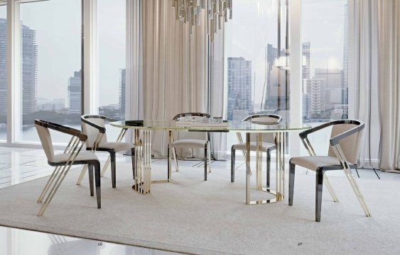 This picture shows a luxurious dining room decorated with high-end furniture and accessories. The room features a large glass chandelier hanging from the ceiling, an ornate framed mirror on the wall, an elaborate wooden dining table with velvet chairs, and an intricate rug on the floor. The overall design is opulent and elegant.