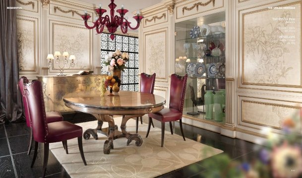 The picture shows a modern, stylish living room. It features large windows that allow plenty of natural light to enter the room, as well as a black leather sofa with gold throw pillows and a glass center table. The floor is a patterned beige marble, and there is an ornate chandelier hanging from the ceiling. The walls are painted in a neutral color, and there is a painting hanging on the wall behind the sofa.