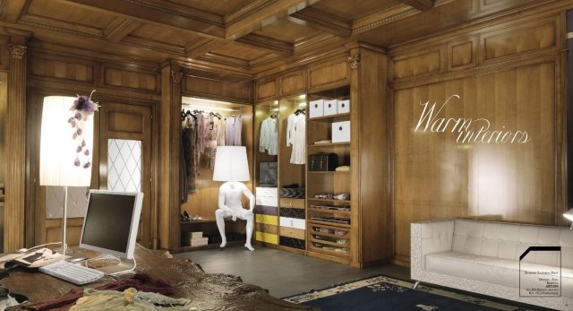 This picture shows a luxurious entryway with a custom steel and glass door. The entrance is decorated with lavish marble flooring in a pale cream color, intricate woodwork, and a grand bronze chandelier. There is an ornate sectional bench and two wall-mounted sconces on either side of the door to offer a warm welcome to visitors.