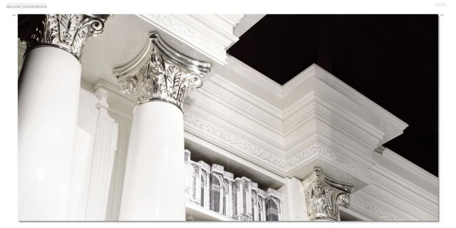 This picture shows a luxurious marble staircase with curved steps, a rich and elegant design, and a very ornate balustrade. The grand staircase is framed by two large marble pillars and accented with detailed crown molding along the walls. The beautiful combination of white and gold creates an impressive and extravagant space.